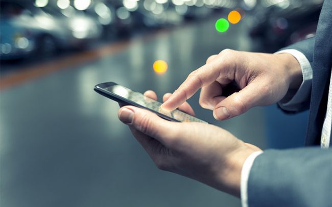 In parking car a man using his mobile phone. Light bokeh backgro