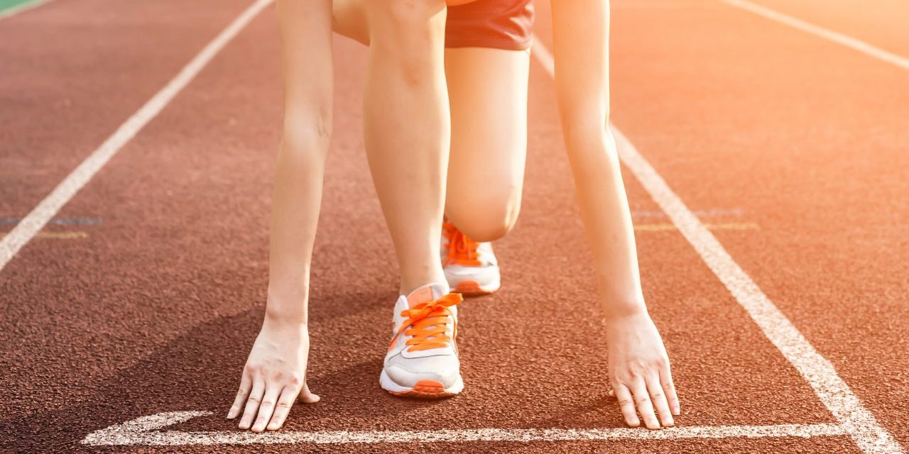 Athletic woman running on track