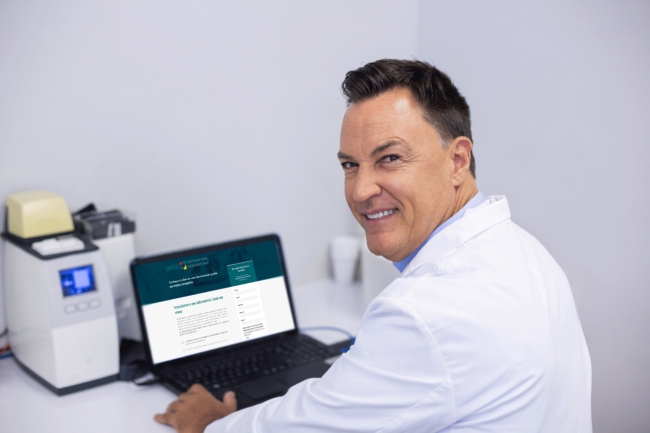 portrait-happy-dentist-examining-x-ray-report-laptop