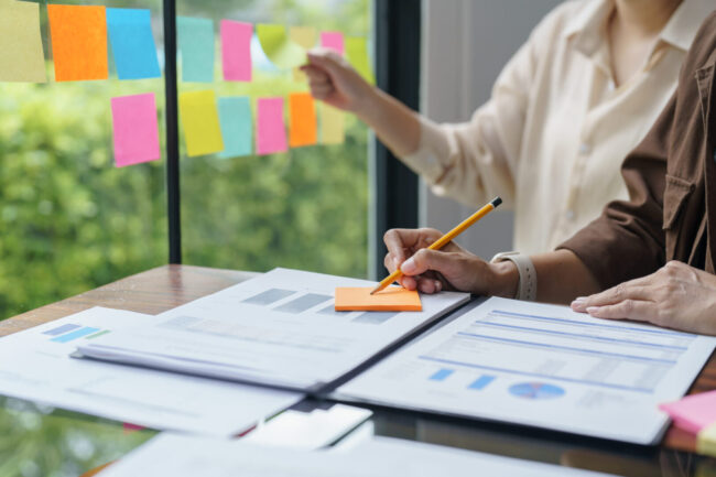 Business People working on sticky notes creative writing down id