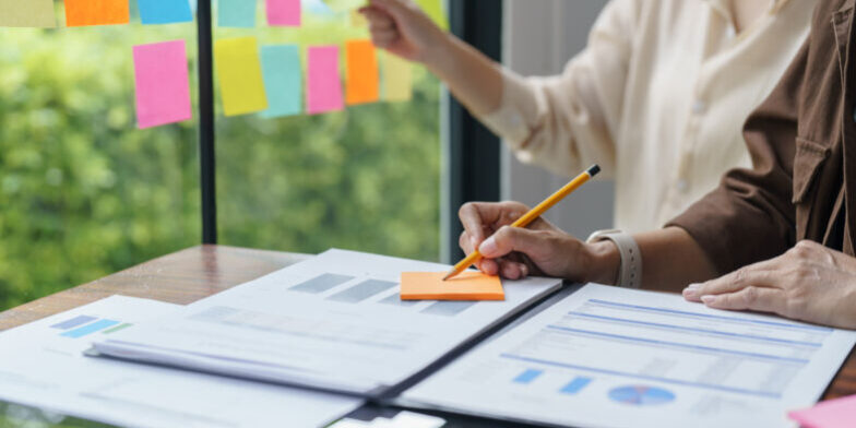 Business People working on sticky notes creative writing down id