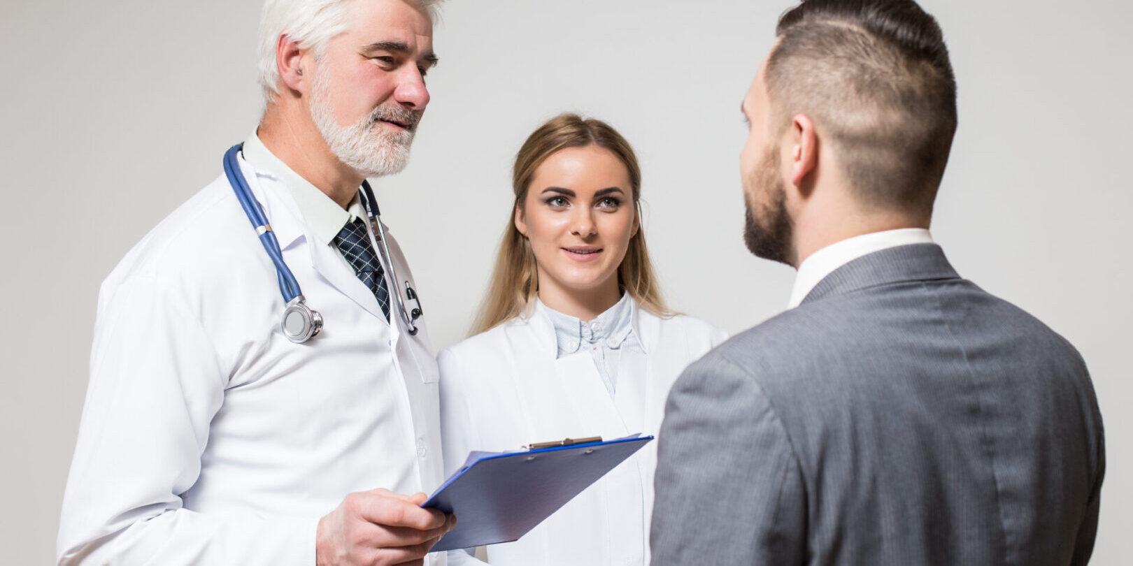 two doctors aged men and young woman with patient young business men