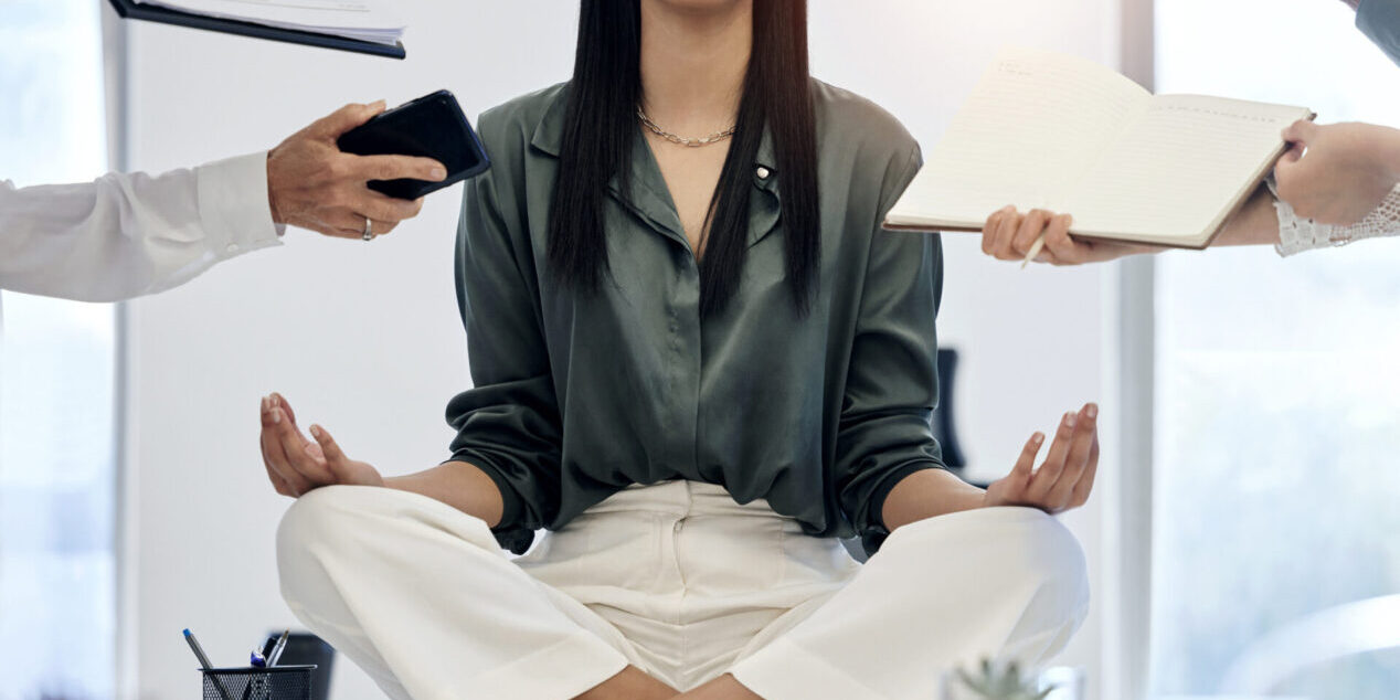 meditation-woman-desk-surrounded-by-work-relax-with-project-deadline-time-management-mental-health-zen-peace-meditate-balance-businesswoman-busy-office-lotus-position