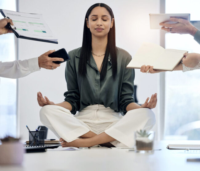 meditation-woman-desk-surrounded-by-work-relax-with-project-deadline-time-management-mental-health-zen-peace-meditate-balance-businesswoman-busy-office-lotus-position